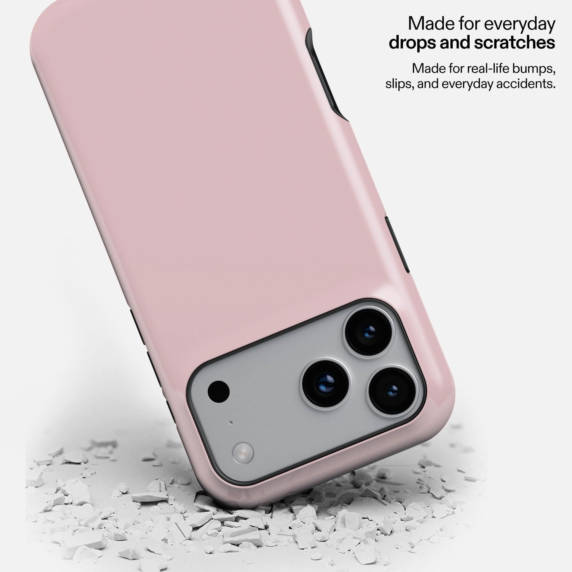 Dusty rose MagSafe tough phone case with triple camera cutout, resting on white debris to show durability.