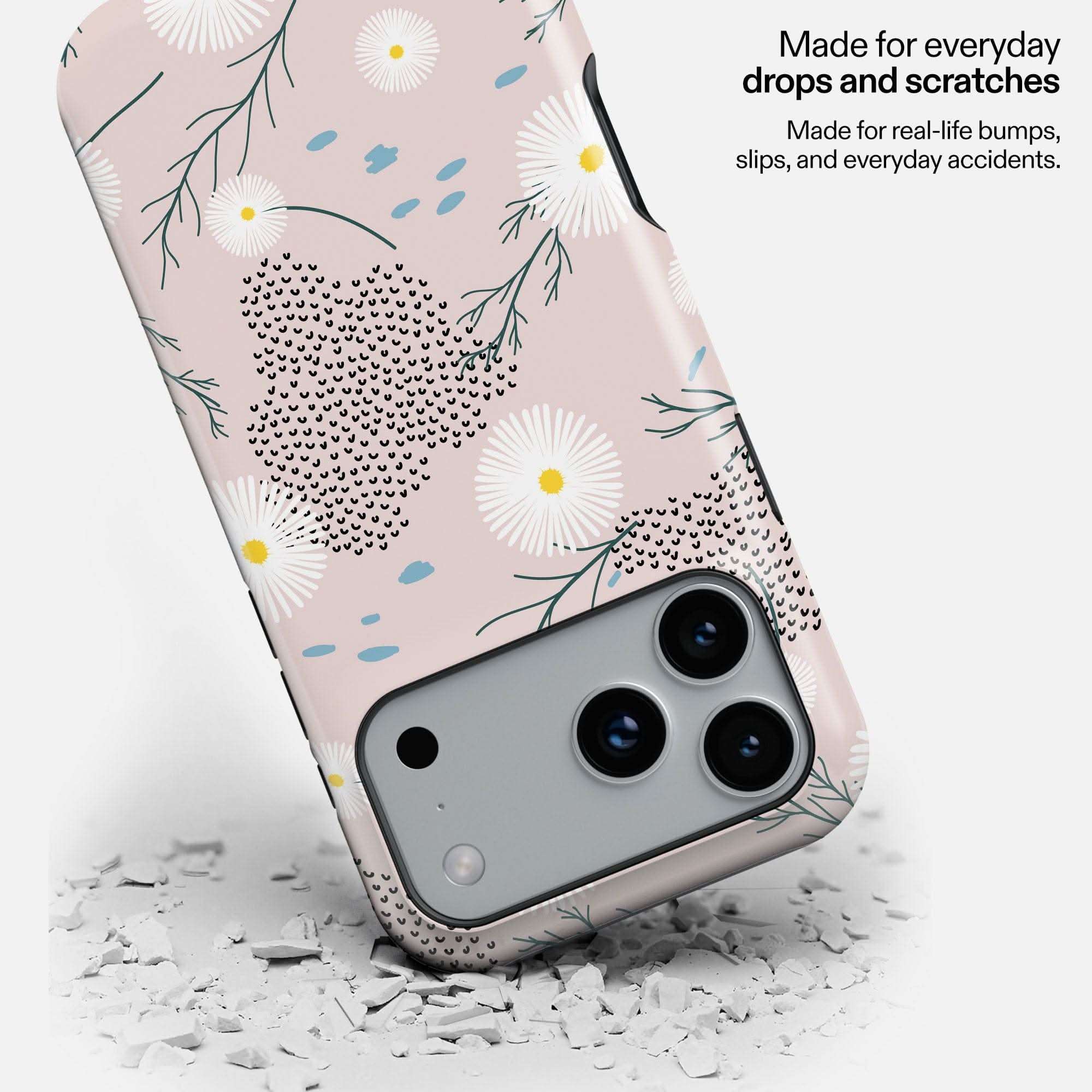 Daisy Haze MagSafe Tough Phone Case with floral design, dropped on white debris to show durability.