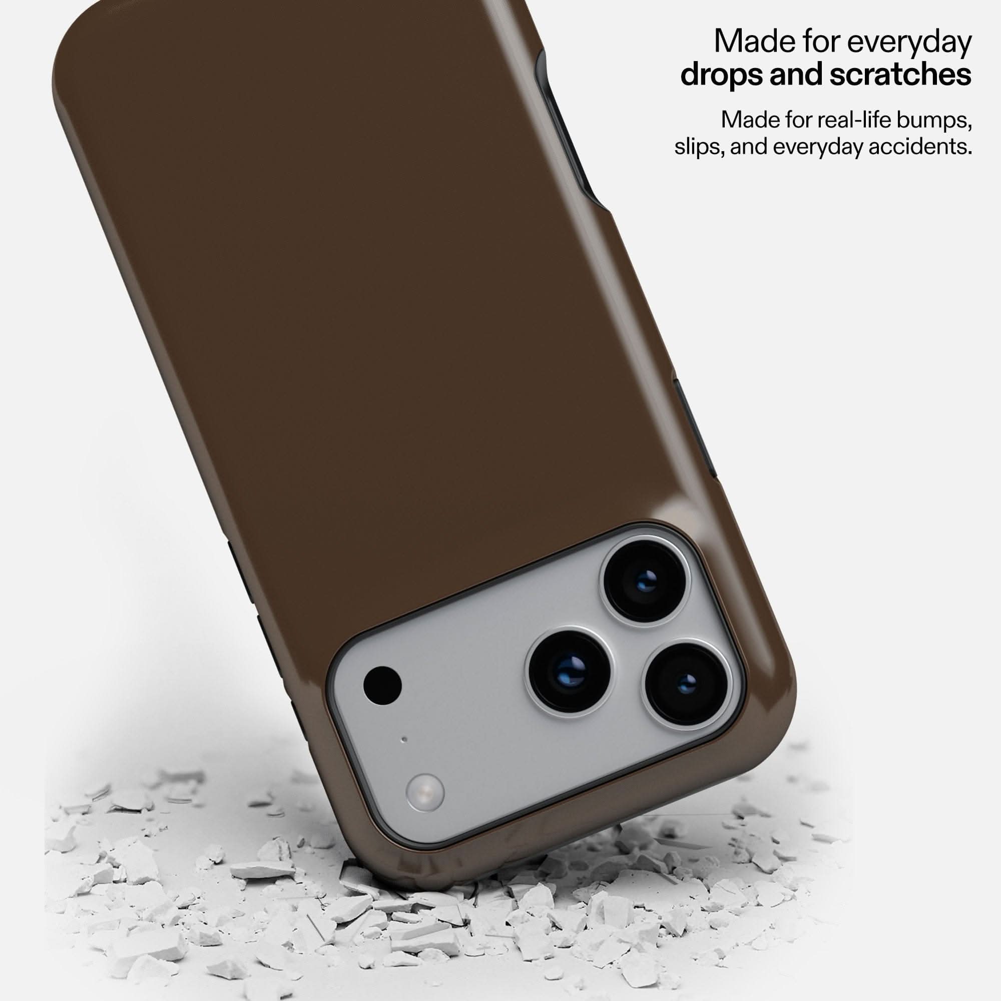 Espresso MagSafe Tough Phone Case protecting smartphone camera, shown on debris surface.