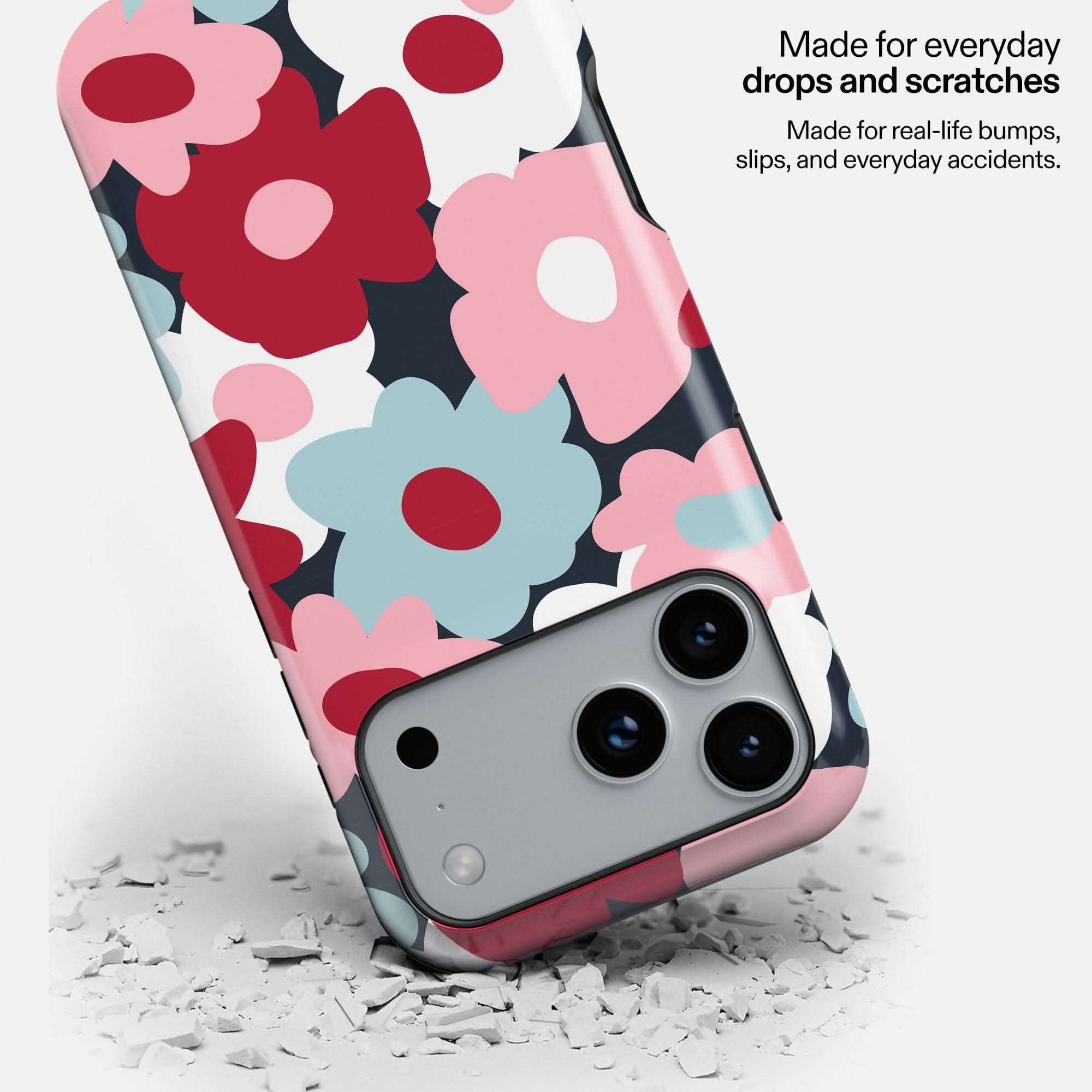 Midnight Petals MagSafe Tough Phone Case with red, pink, and blue flowers on white background, shown on phone with camera detail.