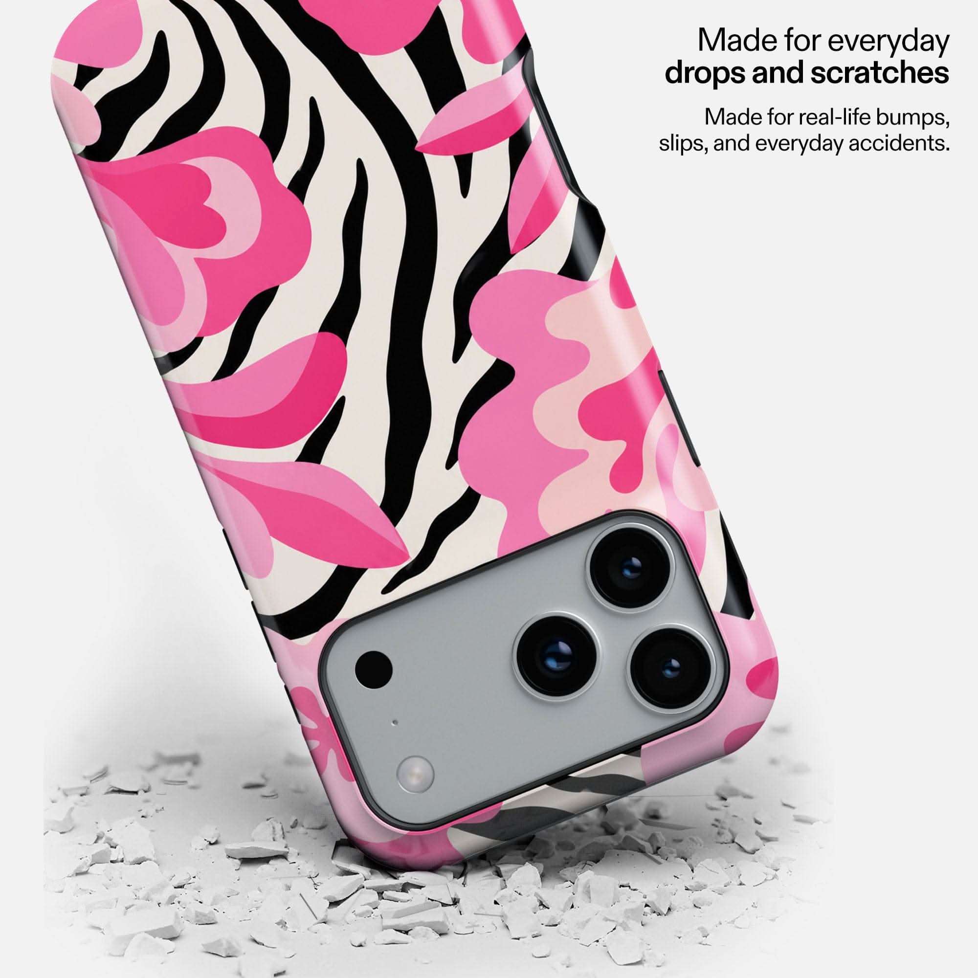Pink Safari MagSafe Tough Phone Case with zebra and floral pattern, shown dropping on white debris.