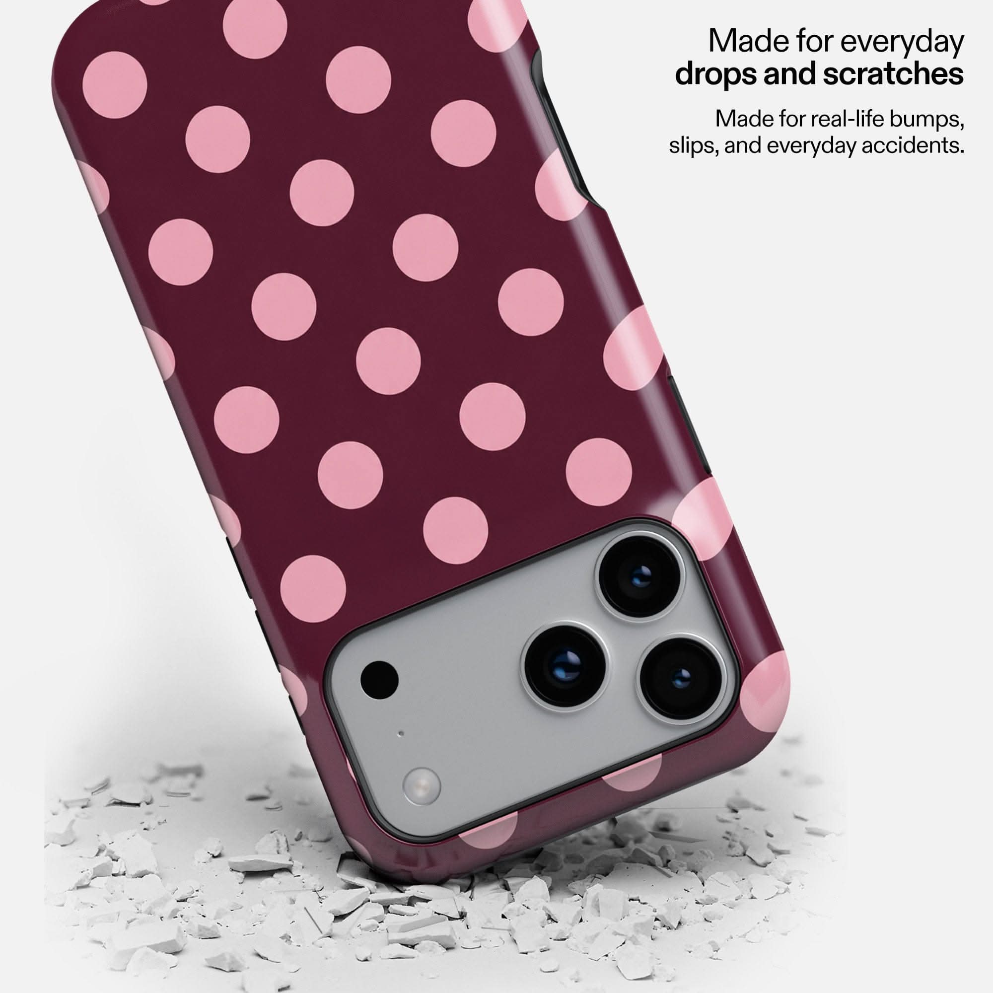 Cherry Soda MagSafe tough phone case with pink polka dots, shown dropped on white debris to demonstrate durability.
