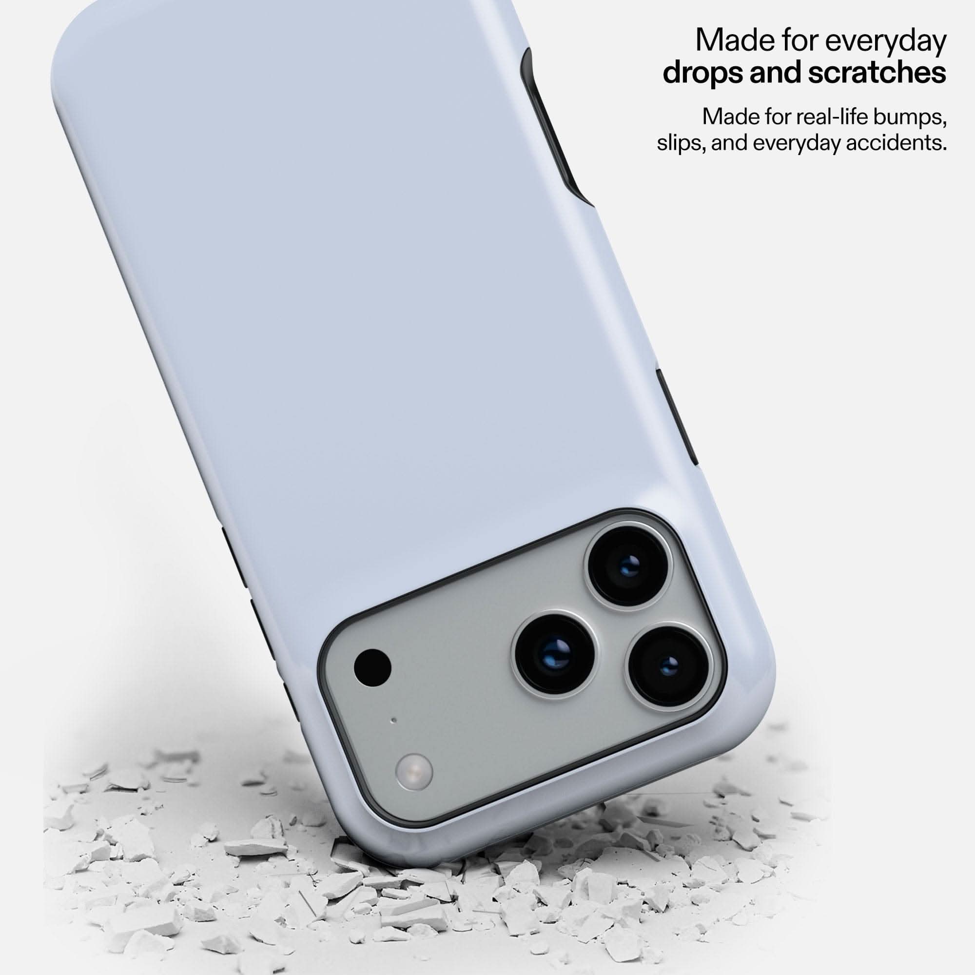 Blueberry Milk MagSafe tough phone case protecting smartphone camera on white debris surface.